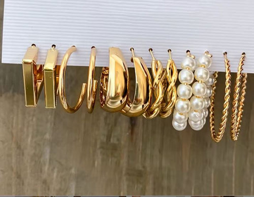 Load image 1 in gallery view. Collection of gold and pearl jewelry on a marble surface with a white background