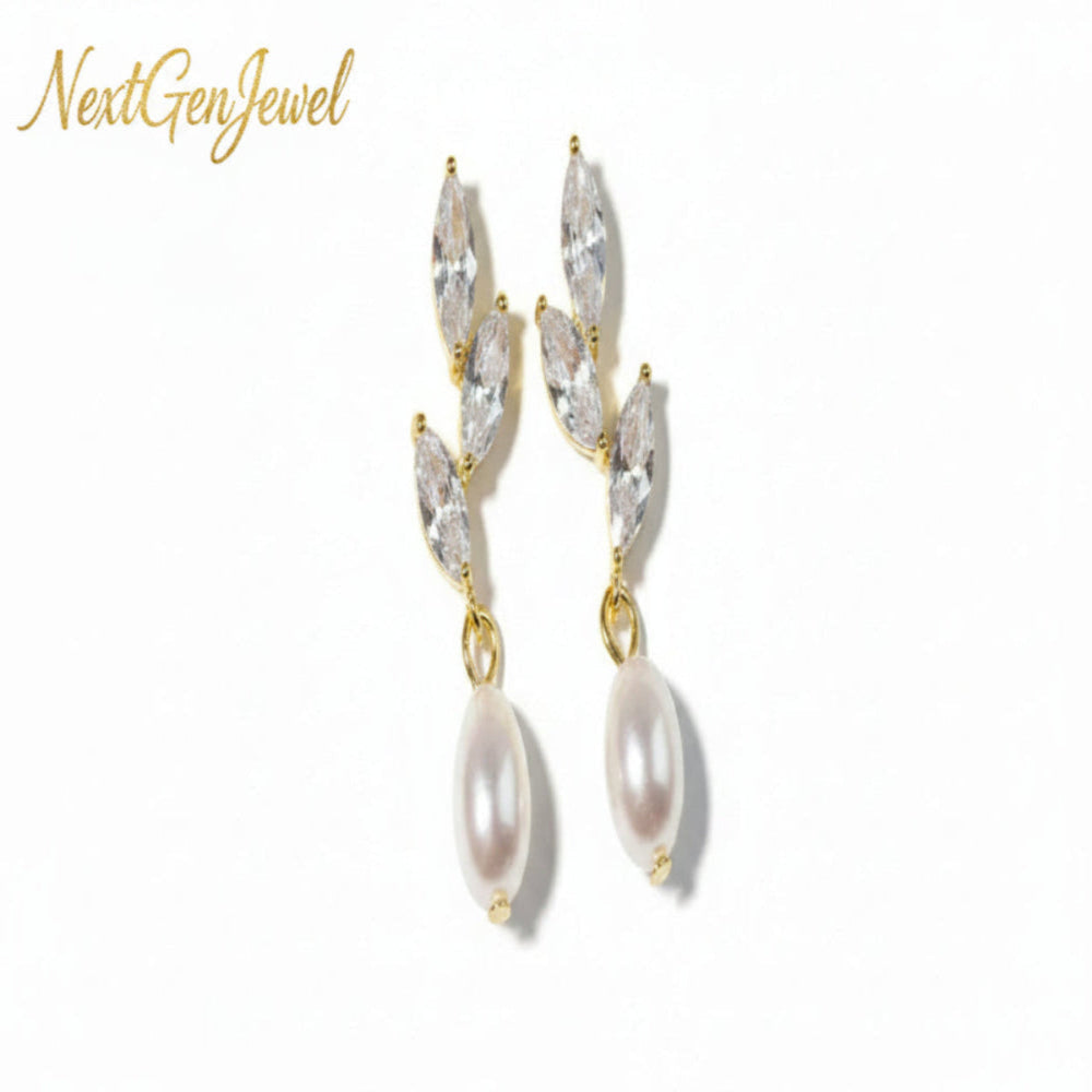 Gold earrings with clear teardrop-shaped crystals and pearl drops on a pink fabric background